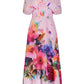 The Lela Rose Watercolor Floral Cotton Voile Isabel Dress, crafted in cotton voile, is a pink midi dress featuring a vibrant watercolor floral print, short sleeves, a gathered waist, and a V-neckline.