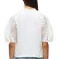 A person is seen from the back wearing the 3.1 Phillip Lim Broderie Anglaise Combo T Shirt with white eyelet lace details, paired with blue denim jeans.
