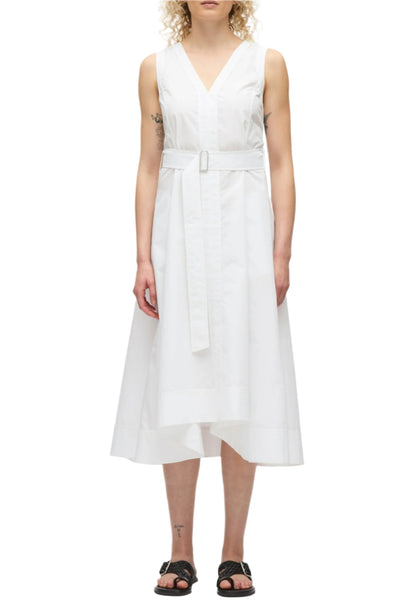 A person wearing the 3.1 Phillip Lim Crisscross Back Midi Dress, a sleeveless white V-neck dress with a belted waist and crisscross back, pairs it with black sandals while standing against a plain white background.