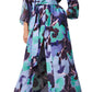 The Solana Dress by Figue, featuring a long floral pattern in blue, green, and purple with long sleeves and a removable self belt, is perfect for spring events when paired with strappy heels.