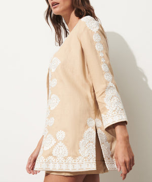 A woman models the Figue Wren Jacket, featuring light tan fabric, white embroidery, and a relaxed fit, shown from the side against a plain light background.