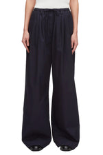 A person wears 3.1 Phillip Lim Structured Cotton Pull-On Straight Leg Pants with a white top and black shoes.