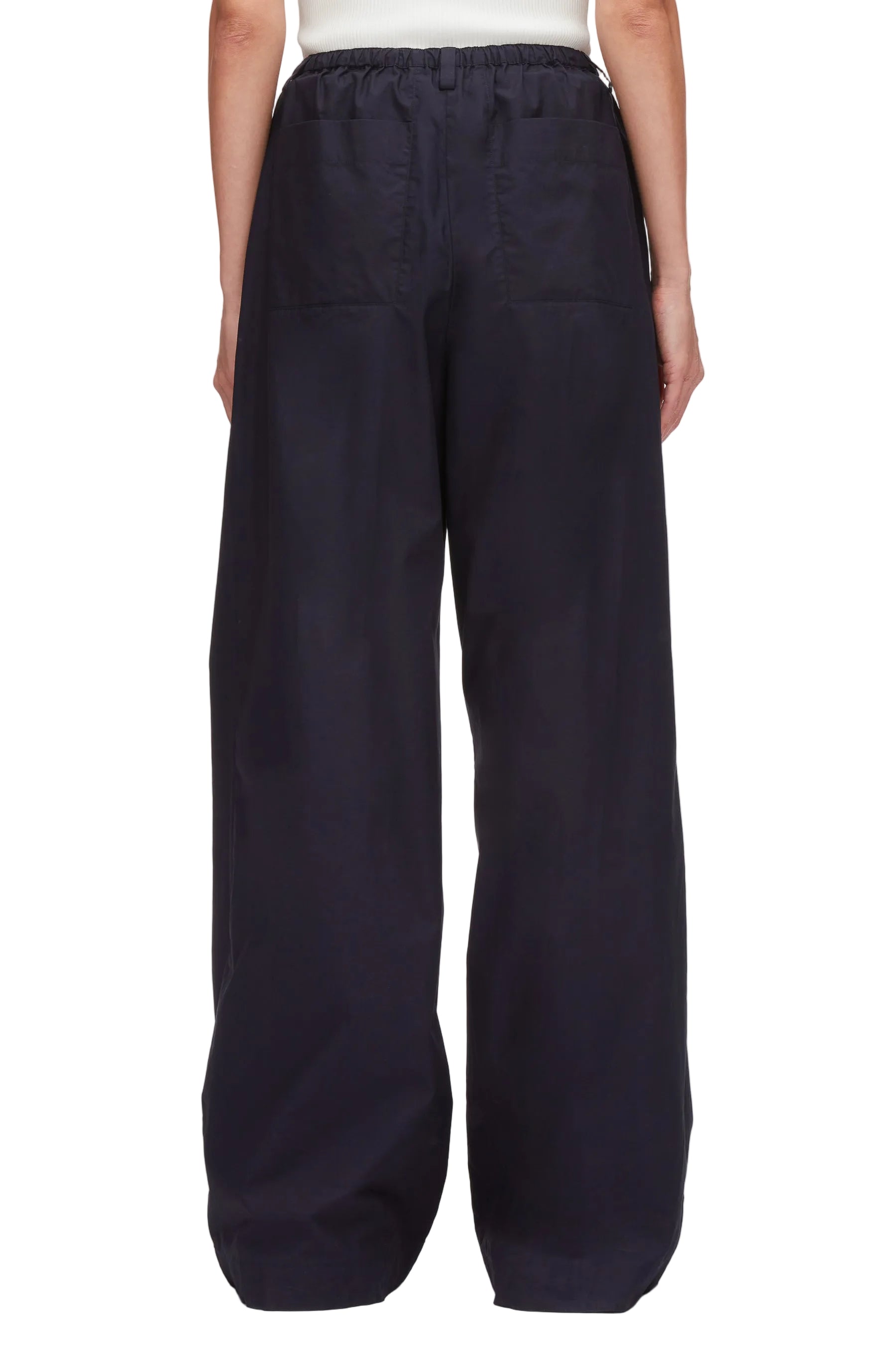 A person is shown from the back wearing 3.1 Phillip Lim Structured Cotton Pull-On Straight Leg Pants, featuring a loose fit and an elastic waistband in dark navy.