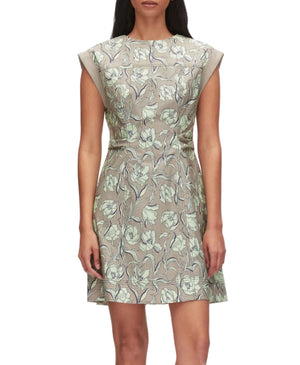 A woman wears the 3.1 Phillip Lim Short Sleeve Floral Mini Dress in pale green and gray, featuring a subtle 60s silhouette as she stands against a plain background.