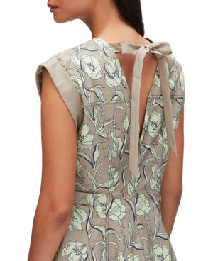 A woman wears the 3.1 Phillip Lim Short Sleeve Floral Mini Dress, featuring a 60s-inspired silhouette and back keyhole detail with a fabric bow.