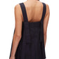 A woman wears the 3.1 Phillip Lim Structured Cotton Poplin Midi Dress, featuring a sleeveless, dark design with a square neckline, wide straps, and two long vertical panels at the back.