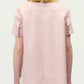 A person is seen from the back wearing the Adam Lippes Charlie Top—a light pink, short-sleeve, collared shirt with vertical white stripes.