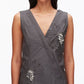 A woman wearing the 3.1 Phillip Lim Draped Tank Dress with a sleeveless, deep V-neck silhouette, featuring floral appliqué and bead embellishments on the left chest and right waist.