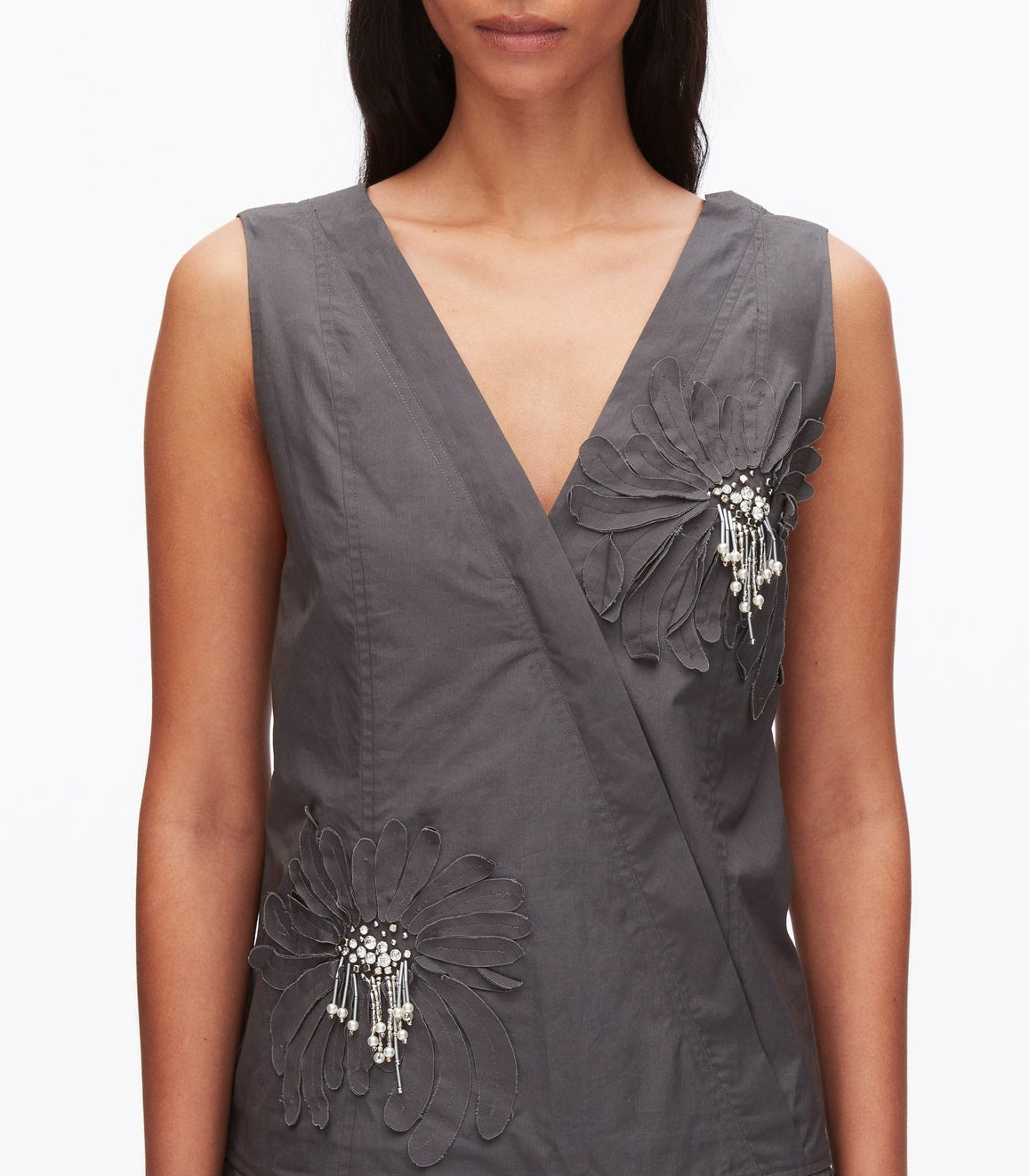 A woman wearing the 3.1 Phillip Lim Draped Tank Dress with a sleeveless, deep V-neck silhouette, featuring floral appliqué and bead embellishments on the left chest and right waist.