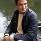 Man smiling while sitting in a boat, wearing a Sid Mashburn Cashpad Traveler's Jacket and recycled cashmere sweater.