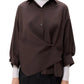 A woman with straight, dark hair wears the TWP New Earl Shirt in a relaxed, oversized fit over a white turtleneck and black pants, standing against a plain white background.