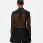 A person faces away, wearing the TWP Peyton Silk Organza Shirt—an oversized sheer design with visible back, opaque cuffs, collar, and lower section. Hair is in a neat bun. Plain white background.