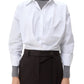 A person wears the oversized TWP Taken Shirt over a gray turtleneck sweater, paired with high-waisted black pants with a tie belt.