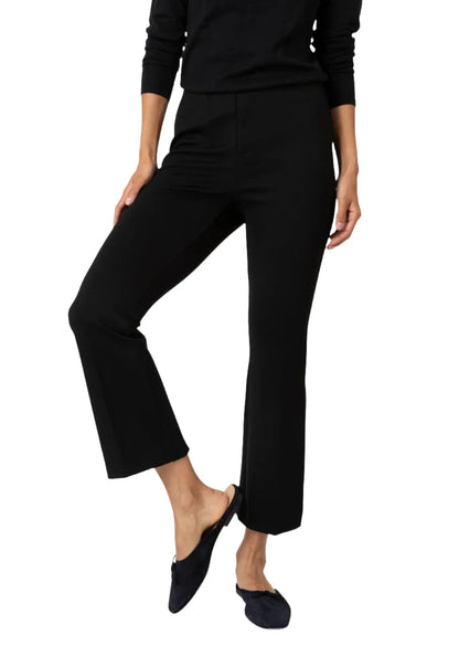 Person wearing Ann Mashburn Faye Flare Cropped Ponte Knit Pant and a black top with black slip-on shoes.