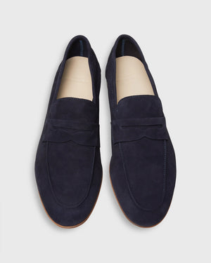 The Ann Mashburn Mia Suede Loafer: navy blue Italian suede loafers with tan insoles and light brown soles—an elevated staple for any menswear collection, shown from above on a plain background.