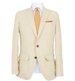 A beige Sid Mashburn Butcher Jacket made from Italian canvas with a pocket square, paired with a blue and white striped shirt and an orange patterned tie, displayed on a mannequin.