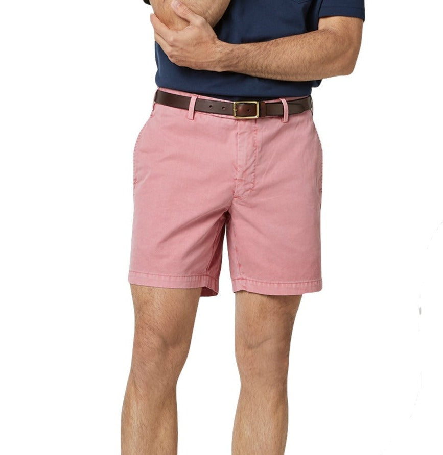 Man wearing pink, Sid Mashburn garment-dyed lightweight cotton twill shorts with a 7" inseam and a blue shirt with arms crossed.