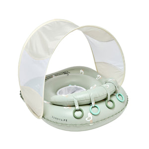 Sunnylife Sammy Seagull Interactive Baby Float features a UPF40 canopy, four green rings on the front for sensory play, a mesh seat, and a light green design with white duck prints.