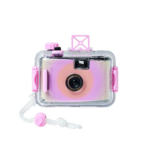 Introducing the Sunnylife Magenta Underwater Camera—a pink and purple retro-style waterproof film camera housed in a transparent waterproof case with a white wrist strap. This focus-free lens camera is shown from the front, set against a clean white background.