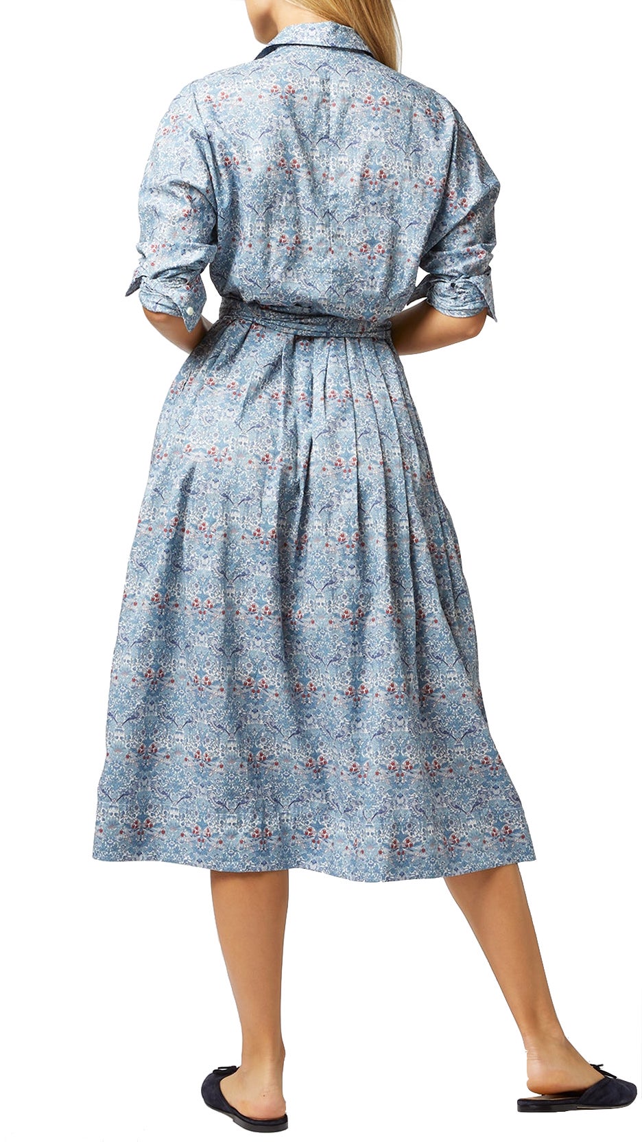 Woman standing with her back to the camera wearing an Ann Mashburn Kimono Shirtwaist Dress in Liberty Fabric blue floral and black flats.