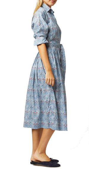 Side profile of a woman wearing a blue Ann Mashburn Kimono Shirtwaist Dress with a cinched waist and black flats.