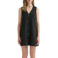 A woman models the POSSE Nancy Mini Dress, a sleeveless black linen mini with a v-neckline, button-front, and straight hem, standing against a white background.
