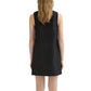 A woman with wavy blonde hair is seen from behind wearing the POSSE Nancy Mini Dress—an A-line, sleeveless black linen mini dress that falls above the knee.