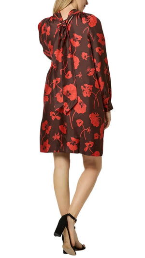 A woman wearing the Ann Mashburn Maggie Dress, a long-sleeve autumn dress in red and brown floral crafted from Liberty Fabrics silk twill, paired with black heeled sandals, is standing with her back to the camera.