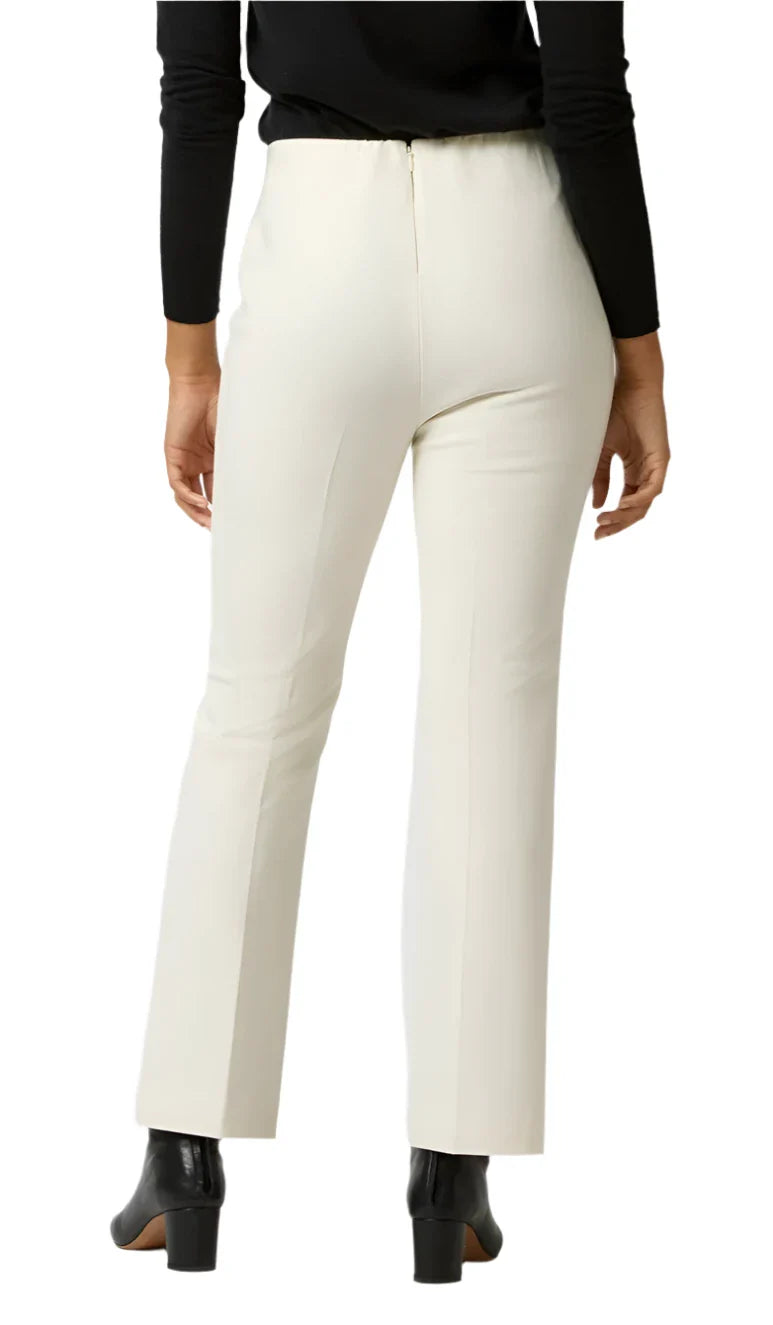 A person wearing figure-skimming Ann Mashburn Fayette Flare Cropped Bi-Stretch Pants and black shoes, viewed from behind against a plain background.