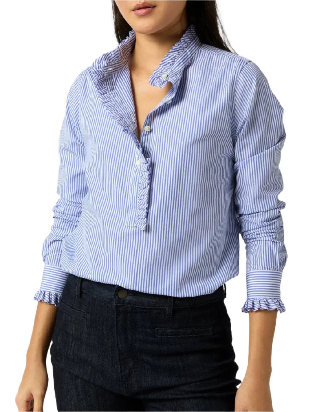 A person wearing the Ann Mashburn Frill Shirt, a blue and white striped blouse made of 100% cotton Italian poplin with a frilled placket, ruffled collar, and cuffs, paired with dark jeans.