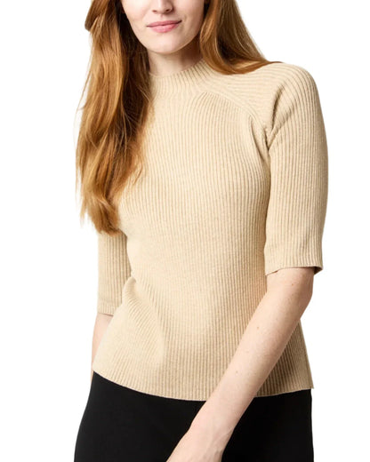 Mackenzie, with long hair cascading down, wears an Ann Mashburn Mackenzie Sweater paired with black pants.