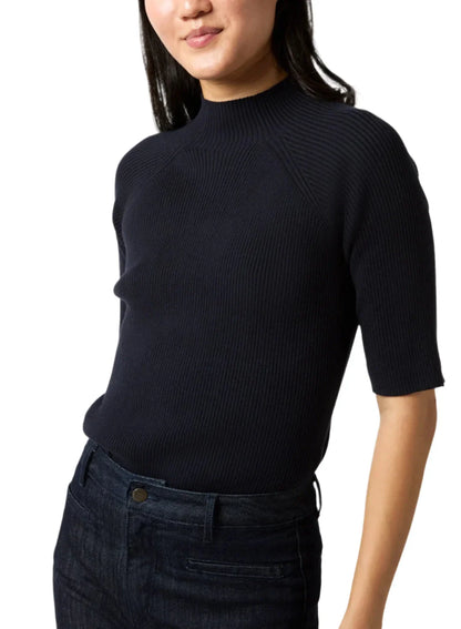 A person wearing an Ann Mashburn Mackenzie Sweater and dark jeans is shown from the waist up against a plain background.