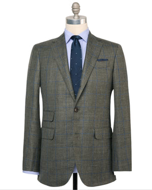 The Sid Mashburn Virgil No. 2 Jacket in green plaid silk-linen with notch lapels and spalla camicia construction is styled on a mannequin with a light blue dress shirt and a navy tie with white dots.