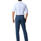 A man faces away, wearing a light blue striped shirt with rolled-up sleeves, Sid Mashburn Sport Trousers in Italian spun fabric, and black shoes, all set against a white background.