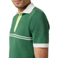 A man wears the Sid Mashburn Rally Polo Sweater—a green slim fit sweater-knit polo shirt with white accents and a crisp white collar.
