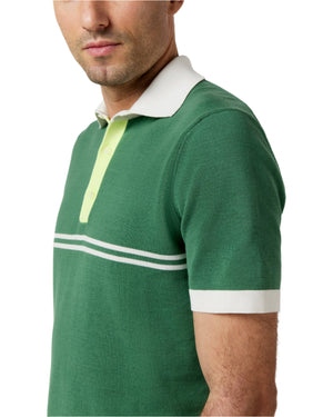 A man wears the Sid Mashburn Rally Polo Sweater—a green slim fit sweater-knit polo shirt with white accents and a crisp white collar.