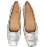 The Ann Mashburn Buckle Shoe is a pair of silver women's flats in metallic goat leather with square toes and front buckle accents, shown from above.