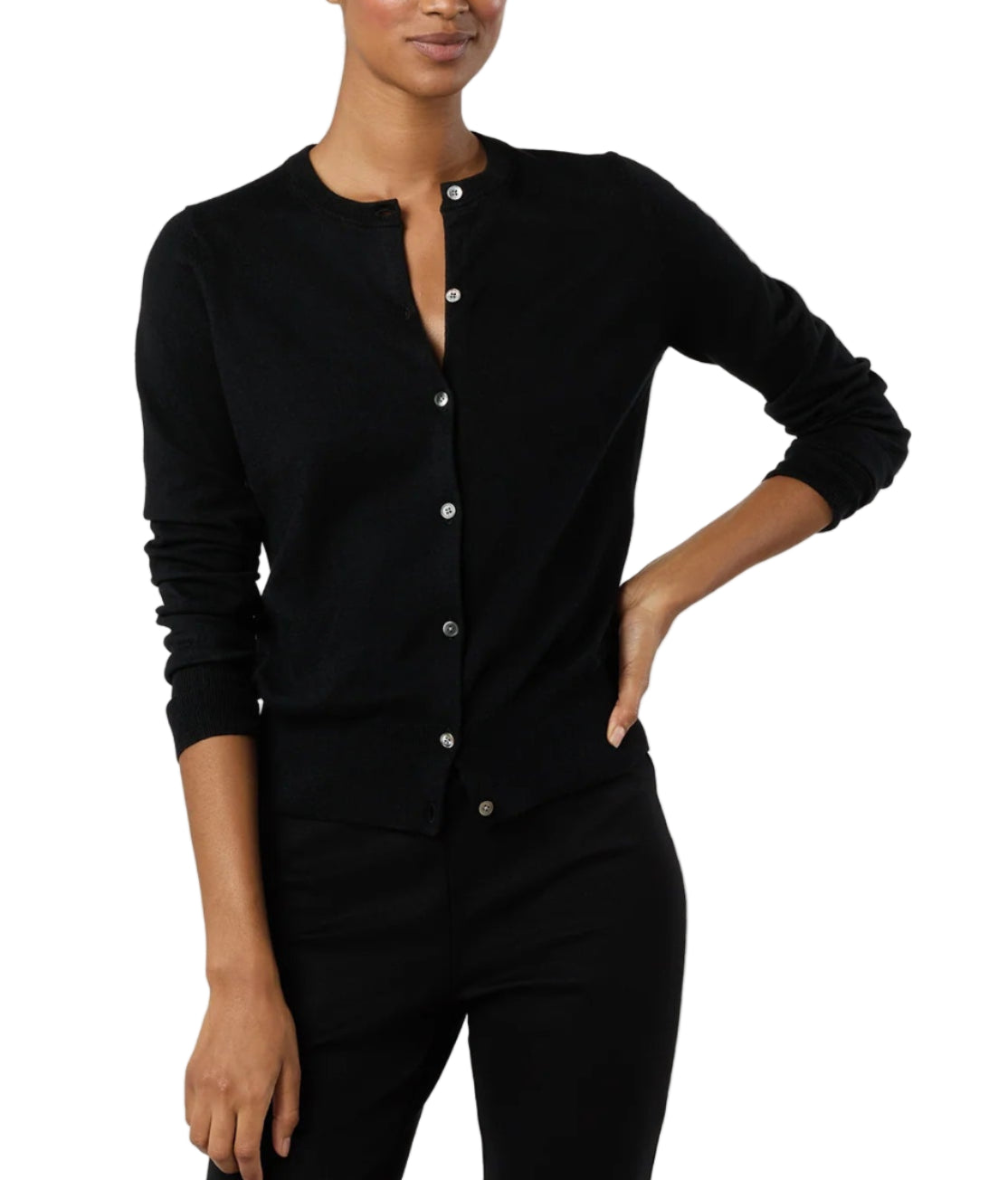 A woman stands with one hand on her hip, wearing black pants and the Ann Mashburn Rosie Cotton Silk Cardigan, a black long-sleeve women's sweater.