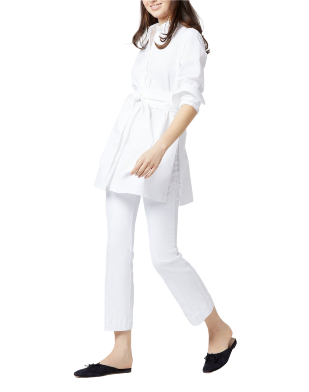 Someone wearing the Ann Mashburn Gabrielle Tie Tunic with white pants and black slip-on shoes walks against a plain background.
