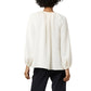 A woman is shown from the back against a plain white background, wearing the Ariana Blouse by Ann Mashburn—a loose-fitting, long-sleeved feminine top in white—paired with black pants.