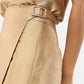 Close-up of a person wearing the Ann Mashburn Renata Silk Shantung Wrap Skirt with a matching belt and a tucked-in gold satin top, highlighting its sleek column silhouette.