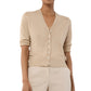 A person models the Ann Mashburn Rosie Cardigan—a beige V-neck, button-up sweater with rolled sleeves—paired with matching beige pants, shown from shoulders to hips.