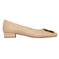 The Ann Mashburn Buckle Basketweave Shoe features a beige woven design with a low block heel and dark toe accent, evoking subtle 1960s style. Shown in profile on a white background.