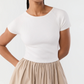 A person wearing the Cosette Cotton Silk Dress by Ann Mashburn, standing with hands behind their back against a plain background.