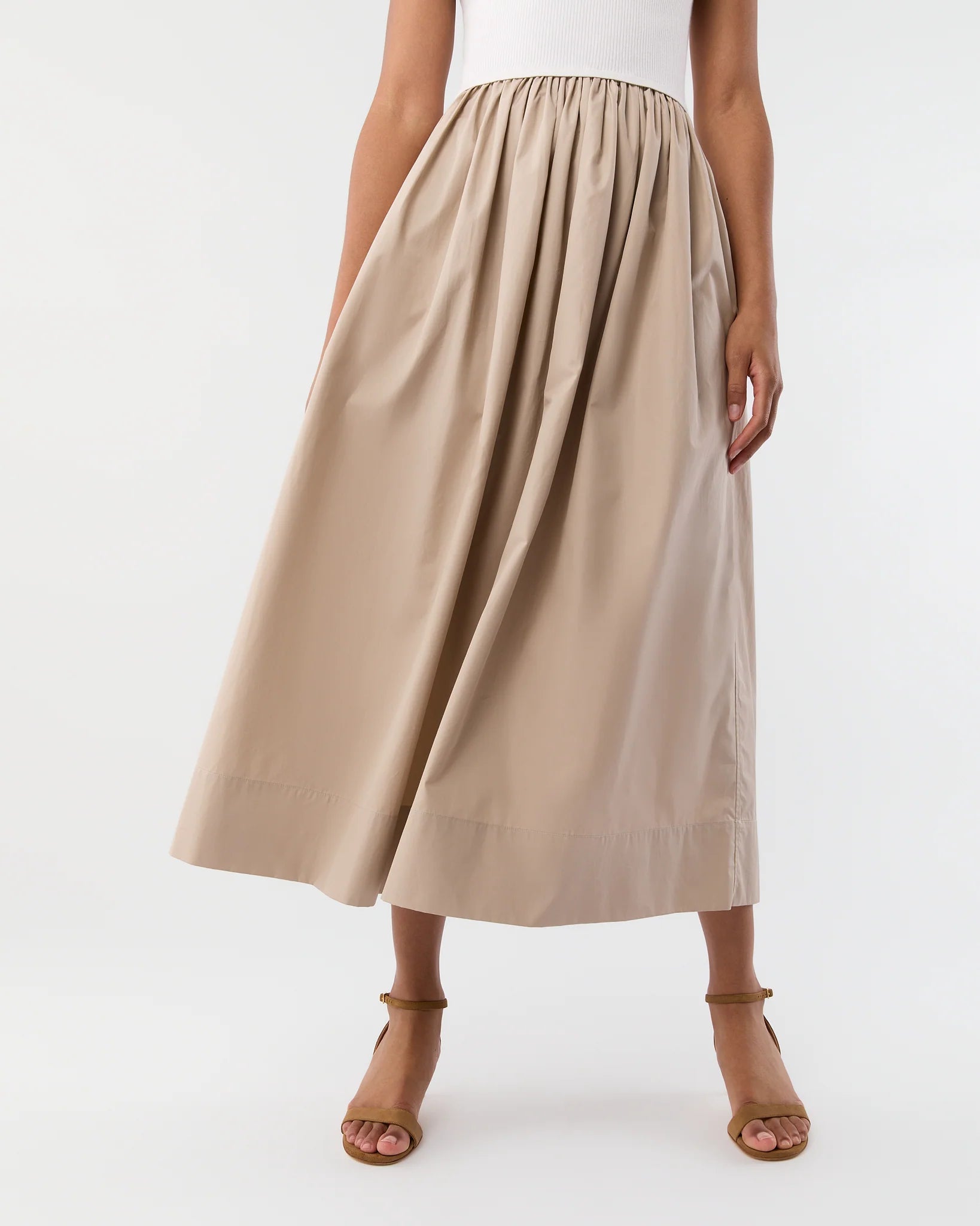A person wearing the Cosette Cotton Silk Dress by Ann Mashburn, with hands resting at their sides.
