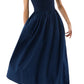 A woman wears the Ann Mashburn Cosette Cotton Silk Dress, featuring a fitted bodice and full poplin skirt in navy blue, paired with black sandals.