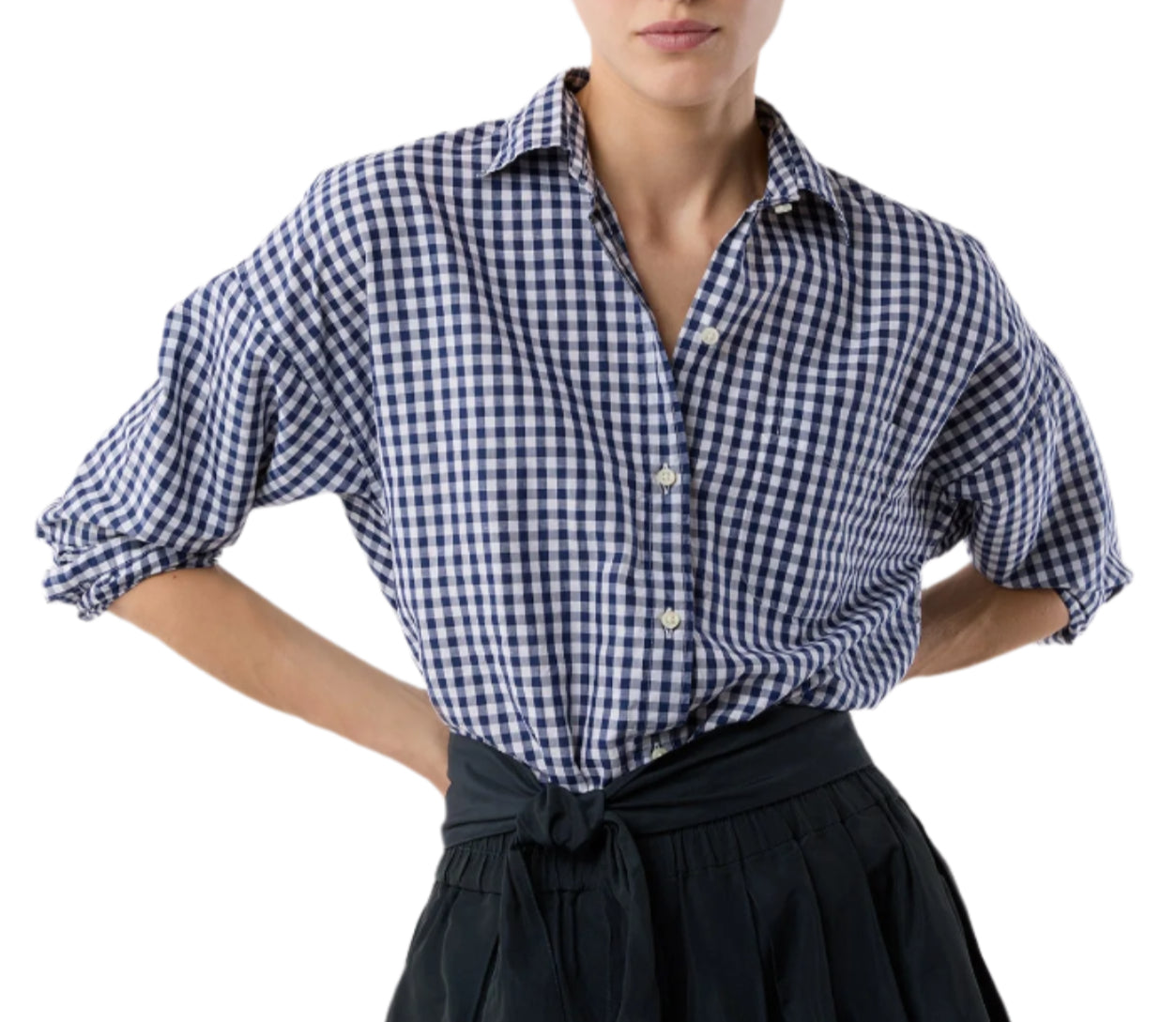 A person wears the Ann Mashburn Weekender Shirt in blue and white checks, sleeves rolled up and tucked into a high-waisted black skirt for a relaxed look.