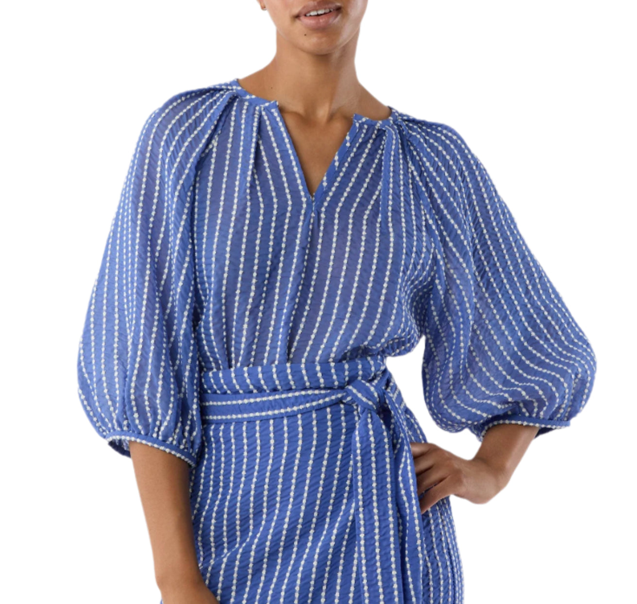 A woman wears the Ann Mashburn Victoria Blouse, featuring blue and white vertical stripes, balloon sleeves, and stretch jacquard fabric with a matching waist tie belt.