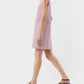 A person is walking against a plain white background wearing the Ann Mashburn Susy Shift Dress—a sleeveless, red-and-white striped 1960s A-line piece—paired with black sandals.