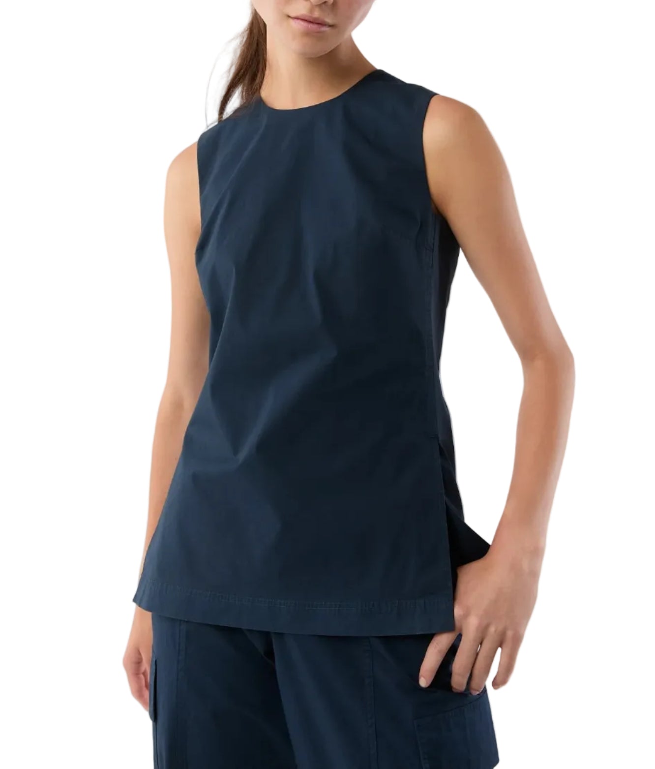 Someone wearing the Ann Mashburn Jo Bi-Stretch Tropical Wool Tunic, a sleeveless navy shell tank with princess seams, paired with matching pants and standing with one hand by their side.